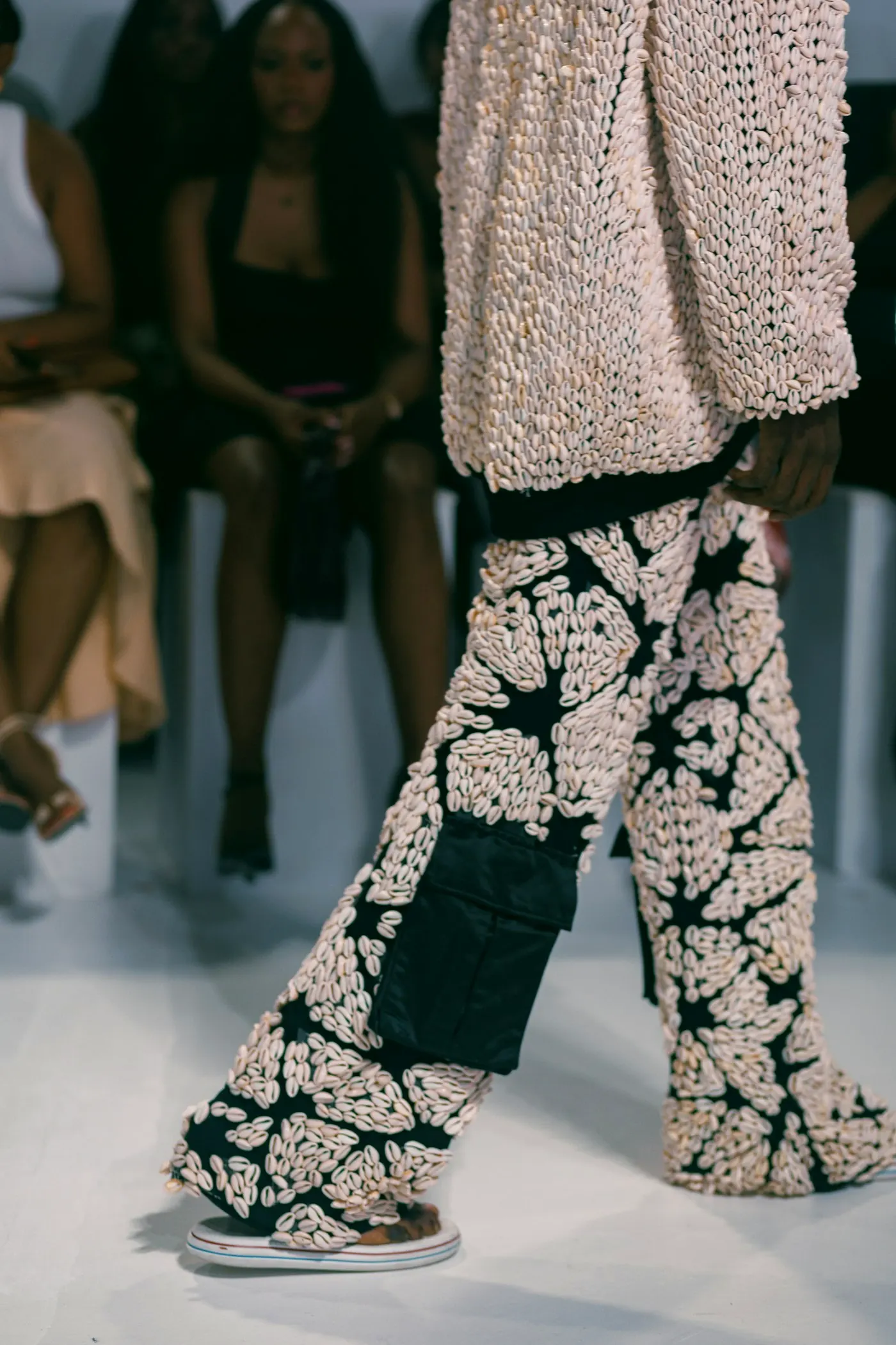 Wide floral-print trousers on a runway.